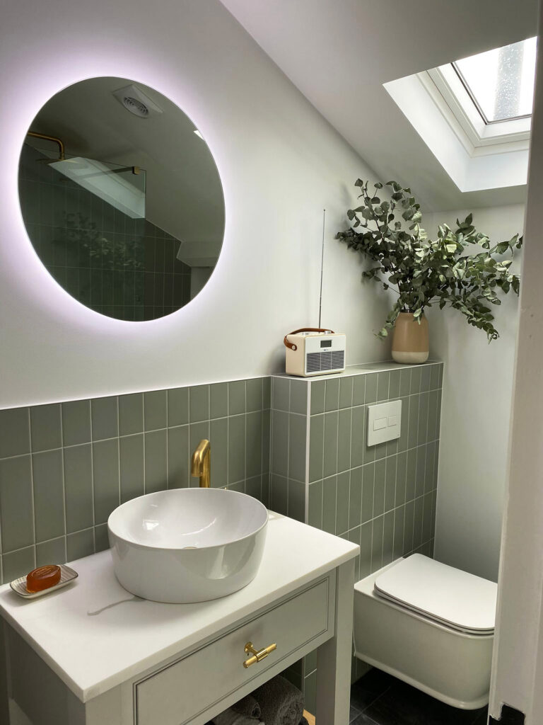 Bathroom with green tiles and a white washbowl