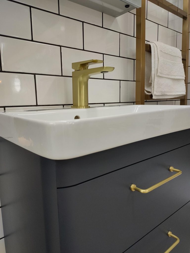 Bathroom vanity with gold fixtures and white subway tiles