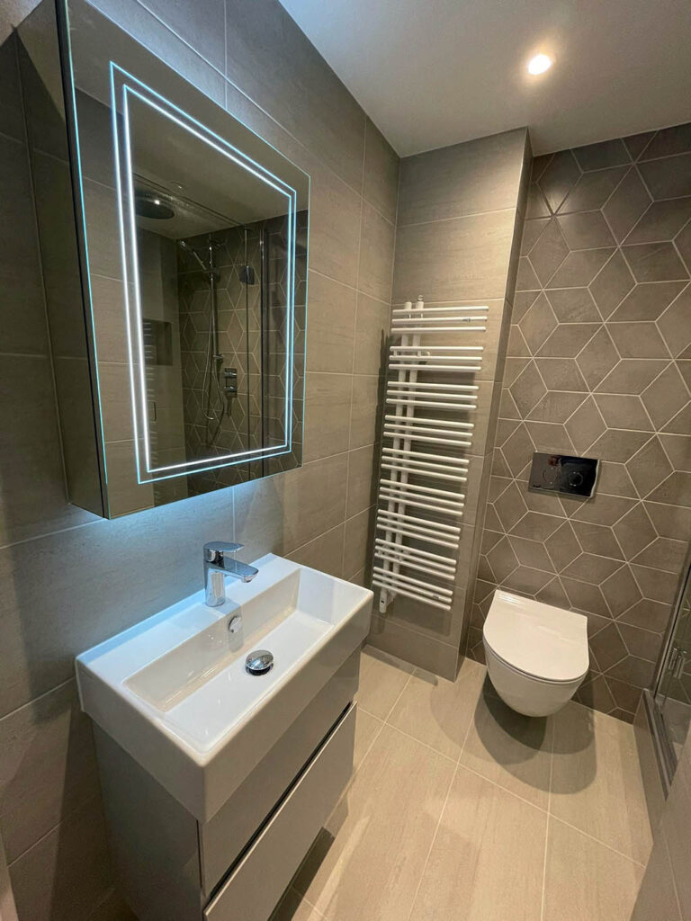 Contemporary bathroom with geometric tiles, a LED mirror, and a walk-in shower