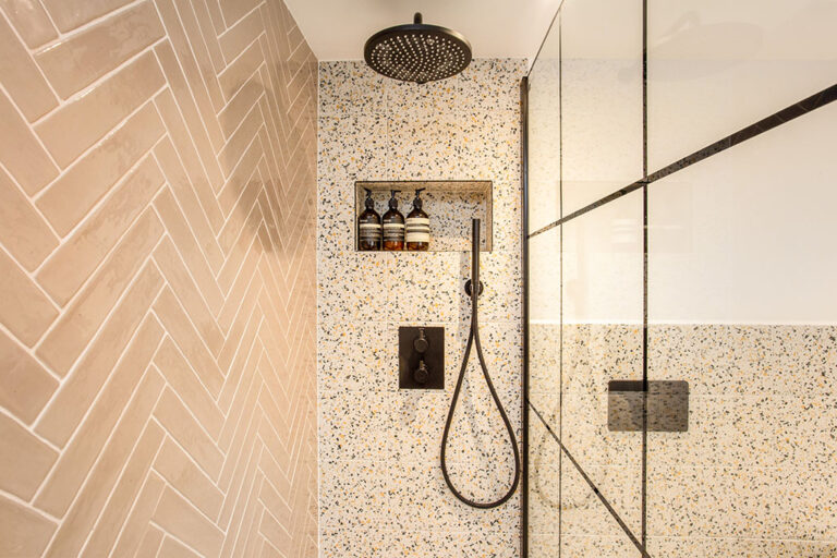 Shower with terrazzo tiles and a black rain showerhead
