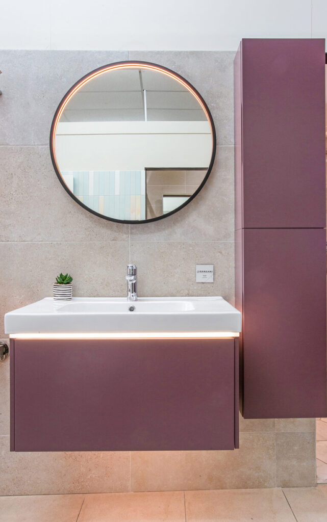 Purple bathroom furniture with a round mirror