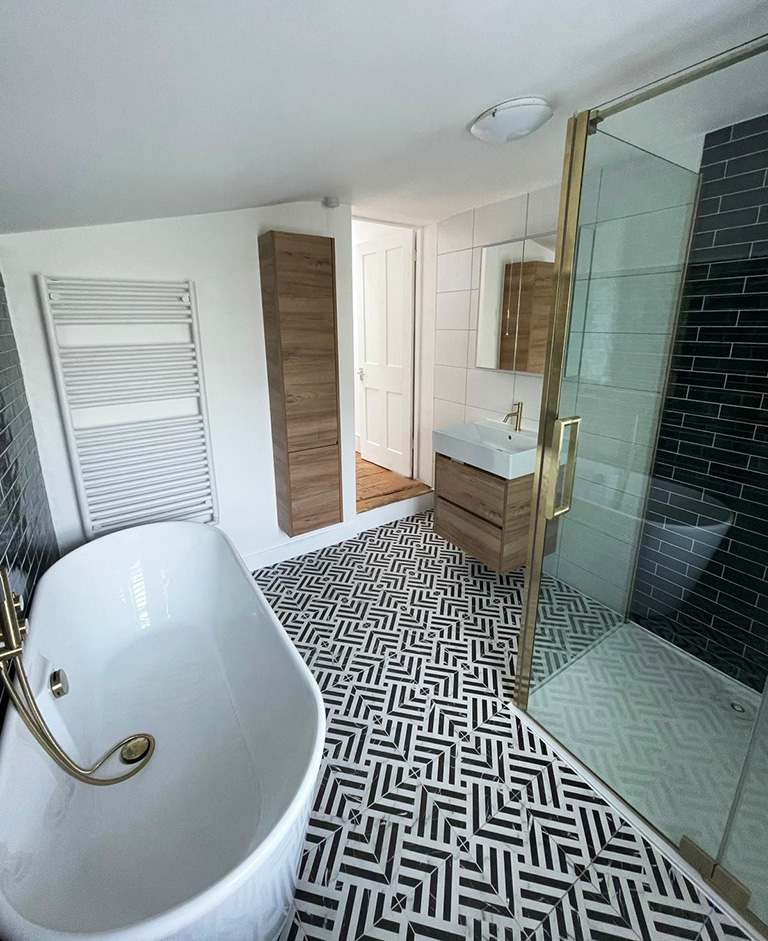 Freestanding bathtub and walk-in shower with gold trim