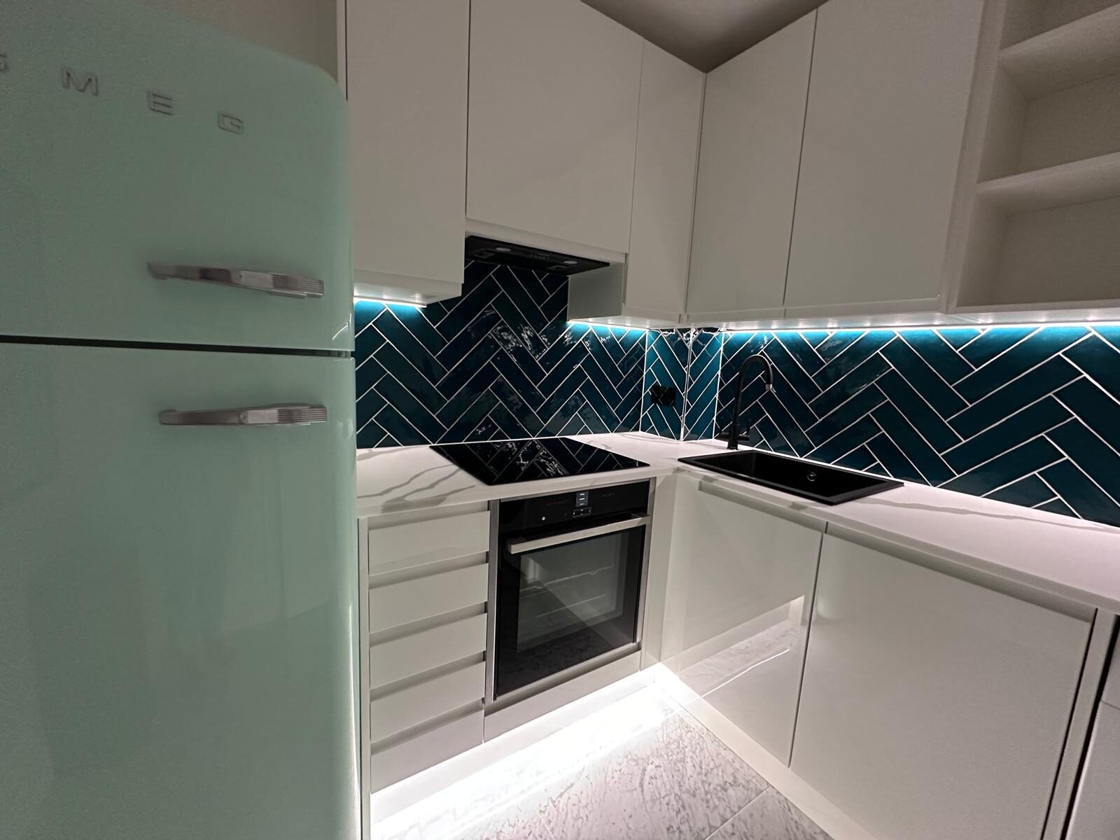 Mint Green Smeg Fridge and Light Worktops With Herringbone Tile Splashback