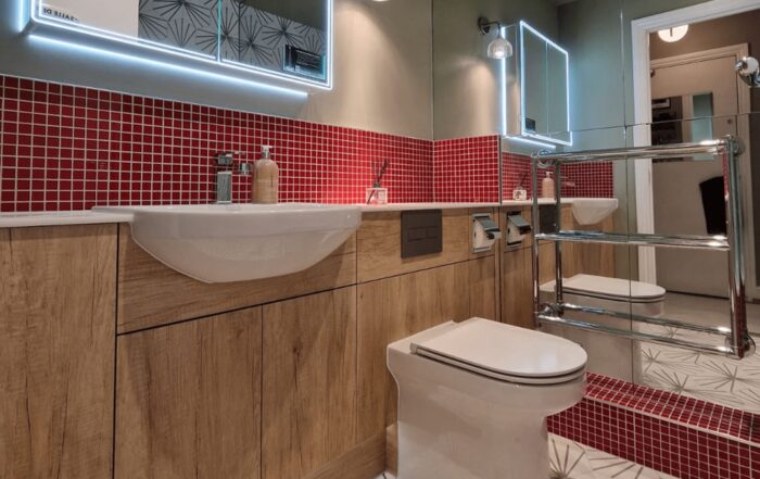 Bathroom sink with red tiles behind.